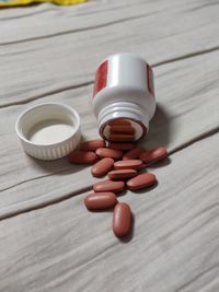 Close-up of medicine spilling from bottle on table