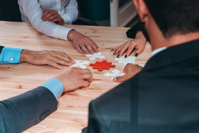 Midsection of man holding jigsaw puzzle at home
