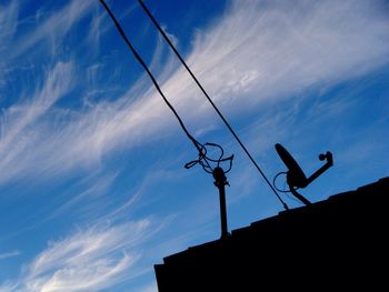 Low angle view of power lines against blue sky