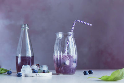 Natural soft cocktail with blueberries, seeds, basil extract, leaves, berries ice. refreshing drink.