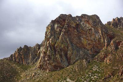 Low angle view of mountain against cloudy sky