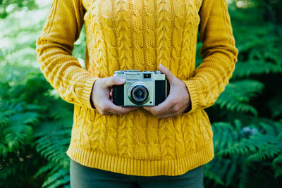 Woman photographing with yellow camera