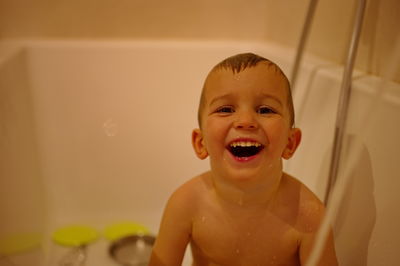 Cute little toddler having shower in bathtub