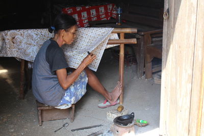 Side view of woman working at workshop