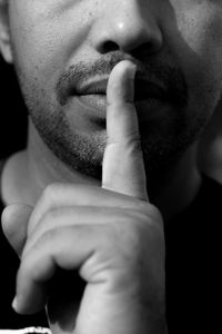 Midsection of mature man with finger on lips
