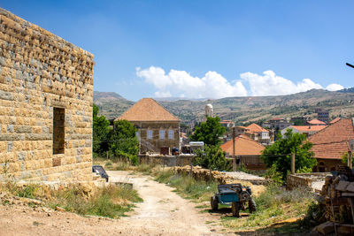 Road amidst buildings against sky