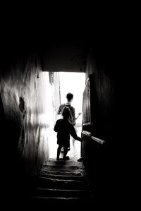 Rear view of silhouette man walking in tunnel