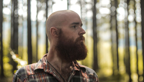 Bearded man standing in forest
