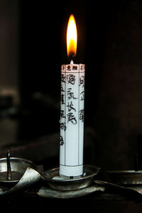 Close-up of lit candle on table