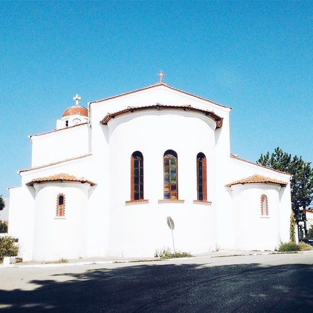 architecture, built structure, building exterior, clear sky, religion, place of worship, church, facade, arch, spirituality, blue, entrance, house, sunlight, day, sky, low angle view, white color