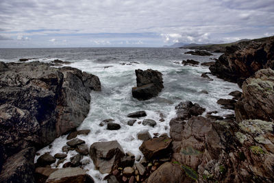 Rocks on beach against sky