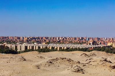 Panoramic view of city buildings against blue sky