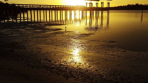 Pier on sea against sky at sunset