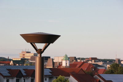 Street light and houses against sky in town