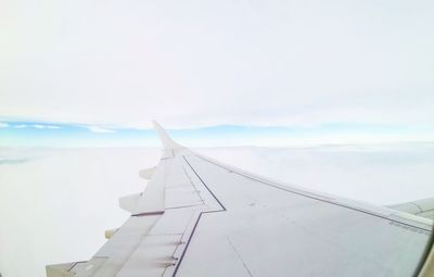 Airplane flying over sea against sky