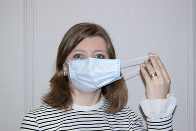 Young woman with protective face mask against white back ground