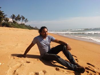 Full length of man relaxing at beach