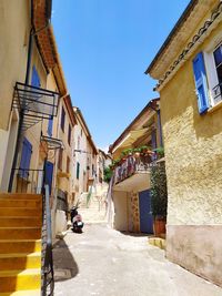 Narrow alley amidst buildings in city against sky