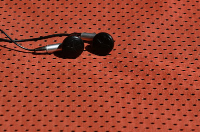High angle view of in-ear headphones on fabric