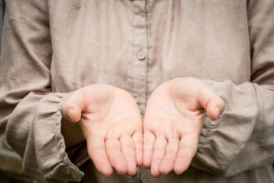 Midsection of woman with hands cupped