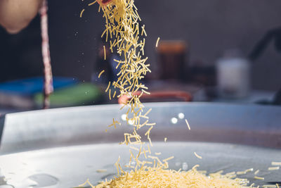 Woman preparing a spanish fideuá with squid prawns and noodles in a paella pan