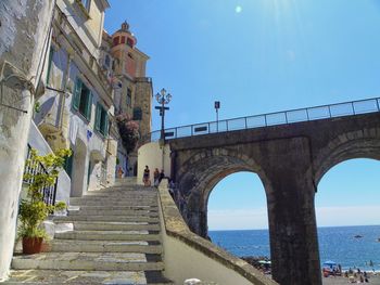 Low angle view of building and bridge by sea