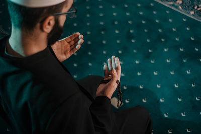 Midsection of man using mobile phone sitting at home