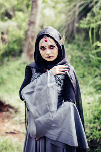 Young woman wearing witch costume while standing outdoors