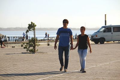 People walking on beach against sky