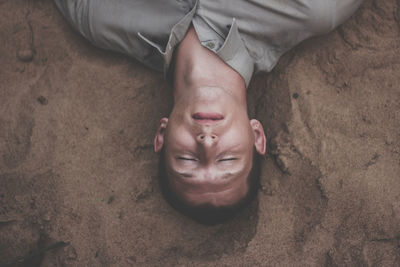 High angle view of man sleeping on sand