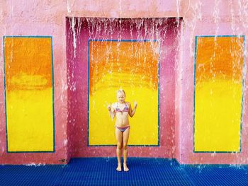 Water falling on girl against wall