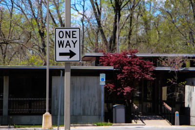 Information sign on pole against trees