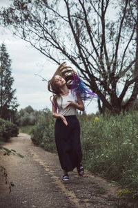 Woman tossing hair while walking on footpath