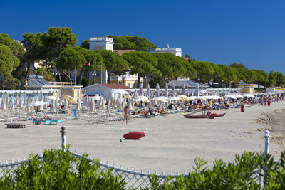 People on beach against clear sky