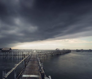 Pier over sea against sky during sunset