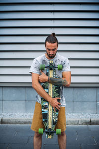 Boy posing with skateboard in hand