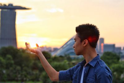 Young man against sky during sunset