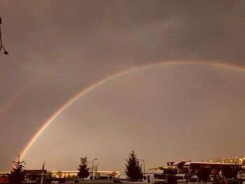 Rainbow over buildings in city against sky