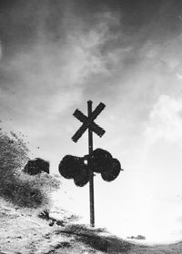 Reflection of railroad crossing sign in puddle on street