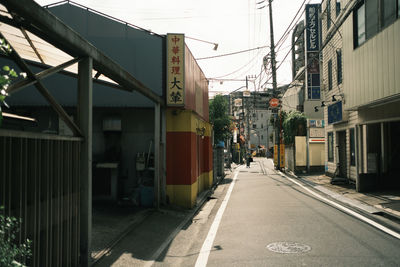 Road amidst buildings in city against sky