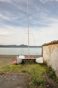 Sailboats moored on sea against sky