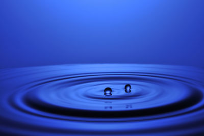 Close-up of water drop against purple background