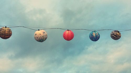 Low angle view of lanterns hanging against sky