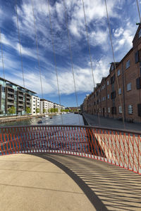 Bridge by buildings in city against sky