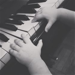 High angle view of hands playing piano