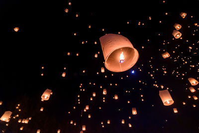 Low angle view of illuminated lantern against sky at night