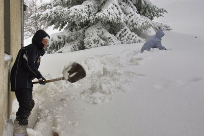 Side view of person on snowcapped mountains during winter