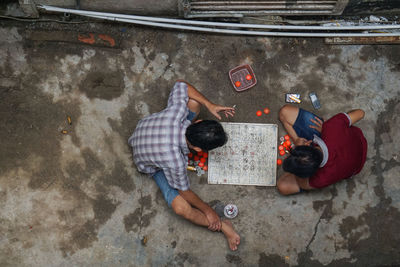 High angle view of friends lying on floor in city