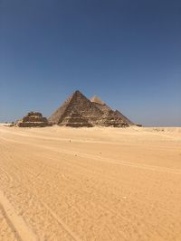 Pyramids at desert against clear sky