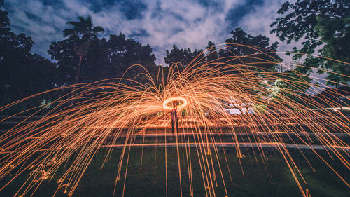 Man spinning wire wool against trees